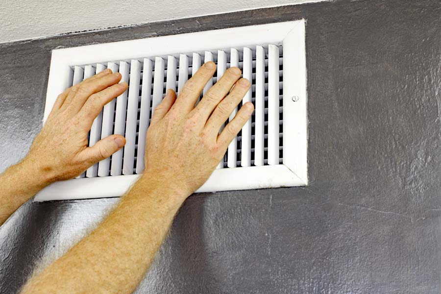 Why Is My AC Blowing Hot Air? Hands in front of vent.